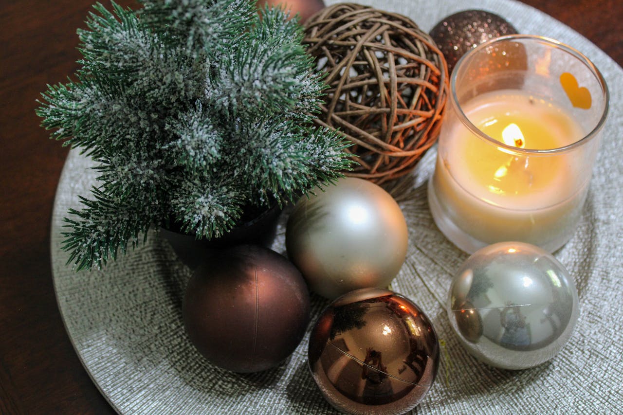 about-img-01 Festive flat lay with a candle, pine, and holiday ornaments creating a warm seasonal atmosphere.